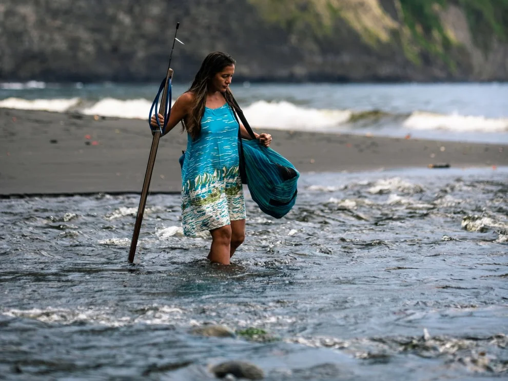 Kimi Werner walks through a stream with her spearfishing gear.