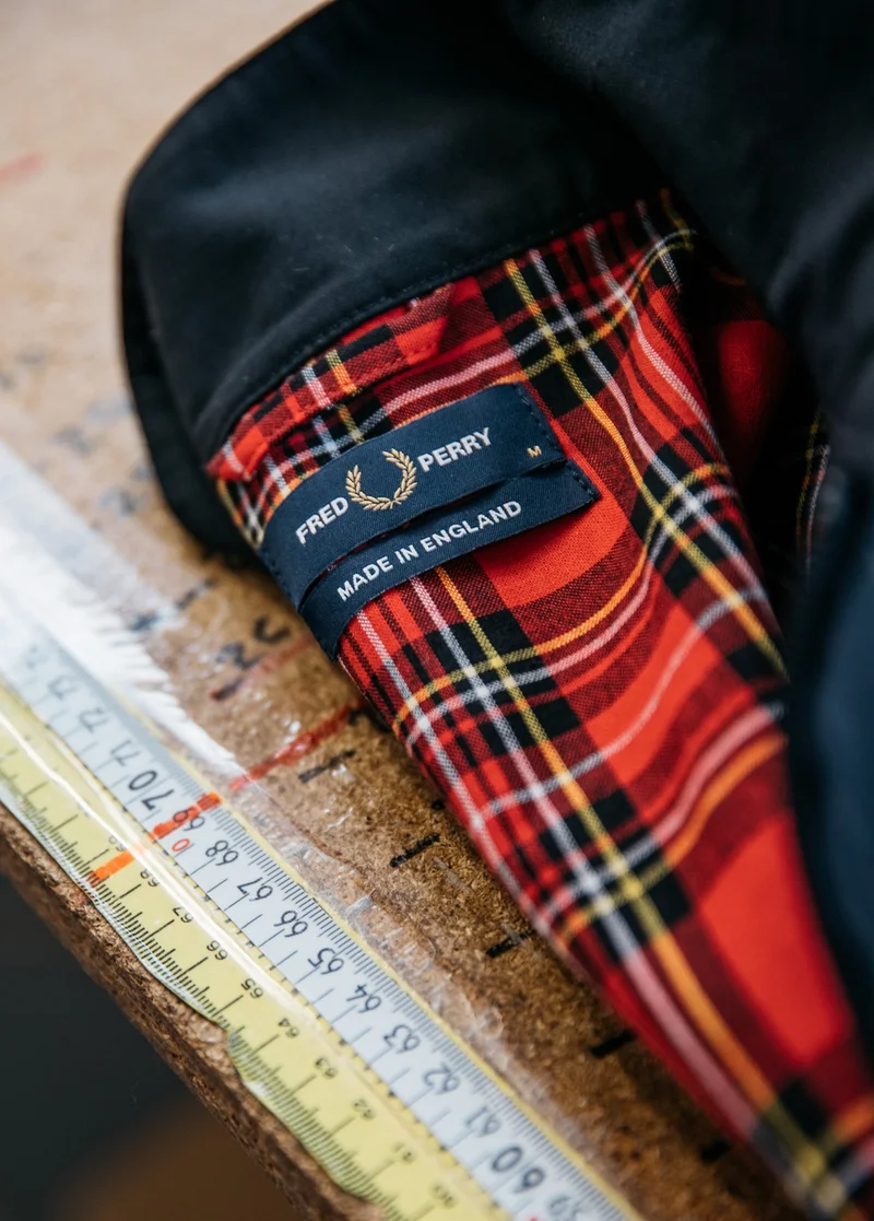 Close up of our Harrington Jacket in black with a red tartan lining