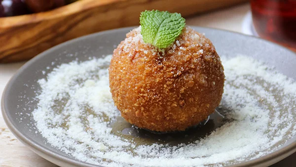 Fried arancini on a tapas plate.