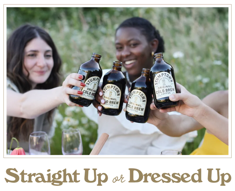 Three people outdoors clinking Stumptown Original Cold Brew bottles in a toast, with the headline “Straight Up or Dressed Up”.