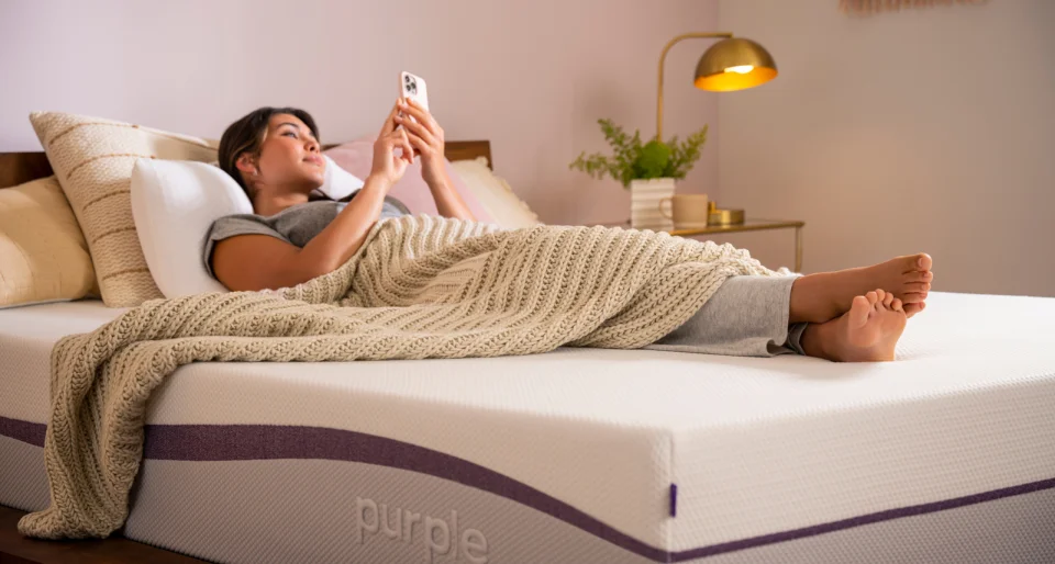 Woman resting on bed with phone