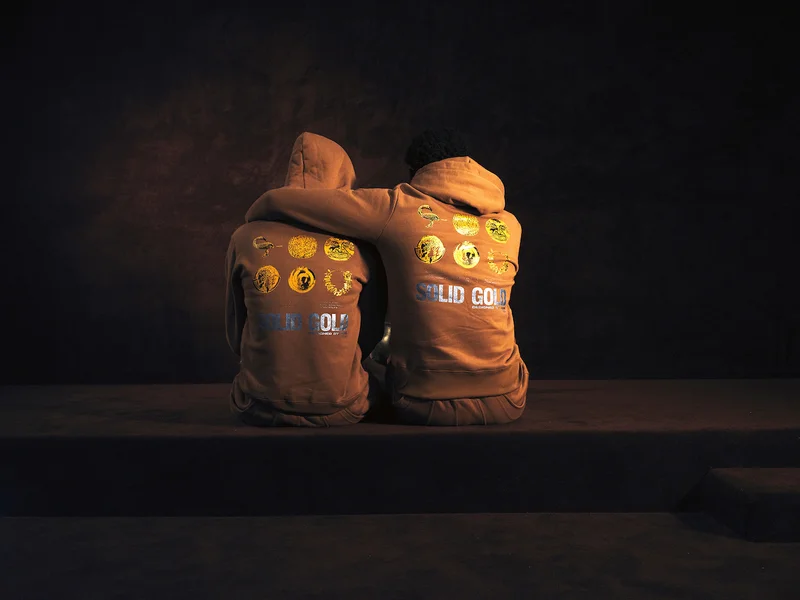 Two people with their backs to the camera, both wearing Solid Gold sweatshirts