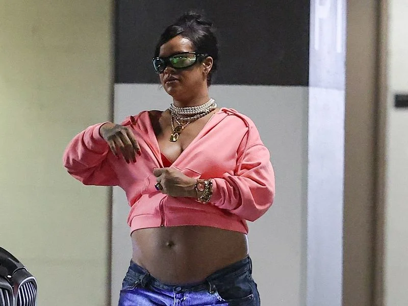 Image may contain: Rihanna, Wristwatch, Person, Arm, Body Part, Accessories, Jewelry, Necklace, Clothing, Glove, and Glasses