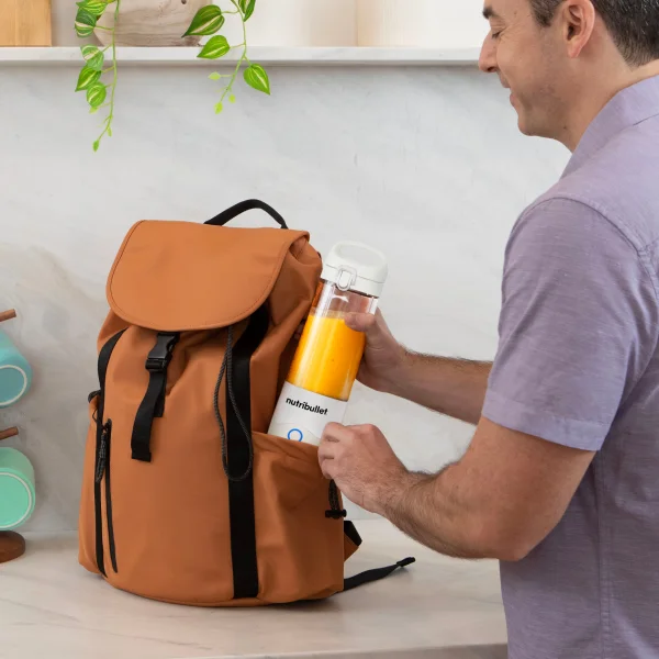 Man placing magic bullet Portable Blender in backpack.