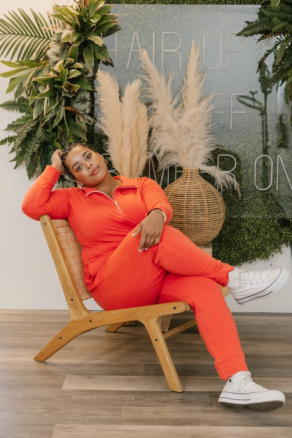 lady wearing red shay romper sat on wooden chair