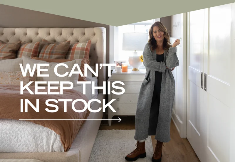 jillian harris in bedroom wearing grey cardigan with 'we can't keep this in stock' text