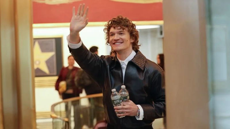 Image may contain: connor storrie, La Parka, Adult, Person, Curly Hair, Hair, Clothing, Coat, Jacket, Face, Happy, and Head