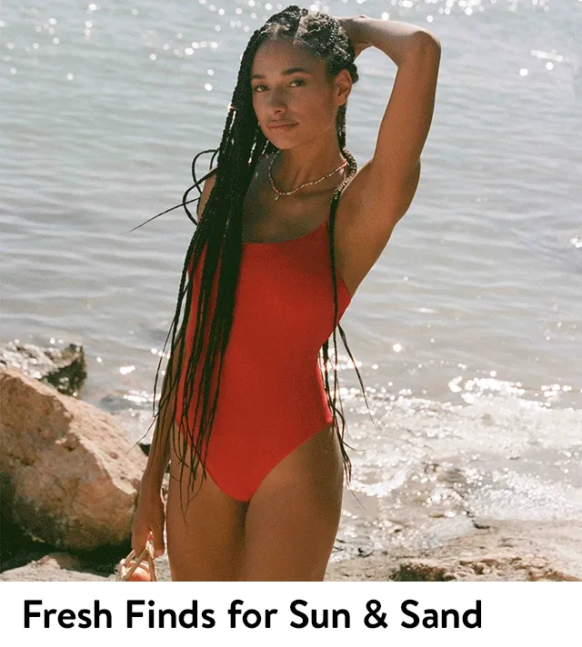 Woman wearing a red one-piece swimsuit. Women wearing black swimsuits.
