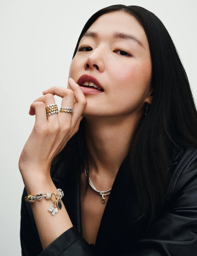 Model wearing Pandora charm bracelet and jewelry