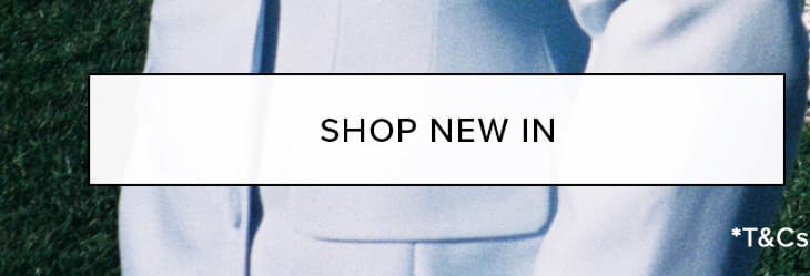 Sleek light blue tailored suit jacket on a model, against green grass, promoting a new collection. Shop New In.