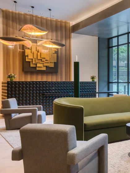 Modular black check-in desk with artful lighting and a welcoming sitting area.