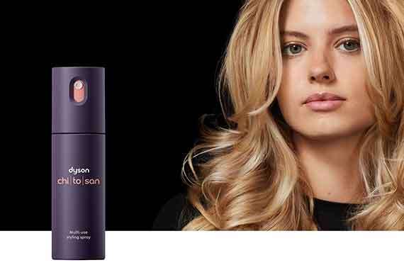 A model with styled hair behind the Dyson Chitosan Multi-use styling spray.