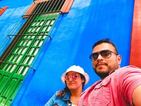 Image Description: Two people in front of a blue wall.