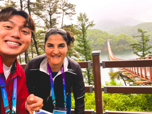 Image Description: Two people by a bridge near water.