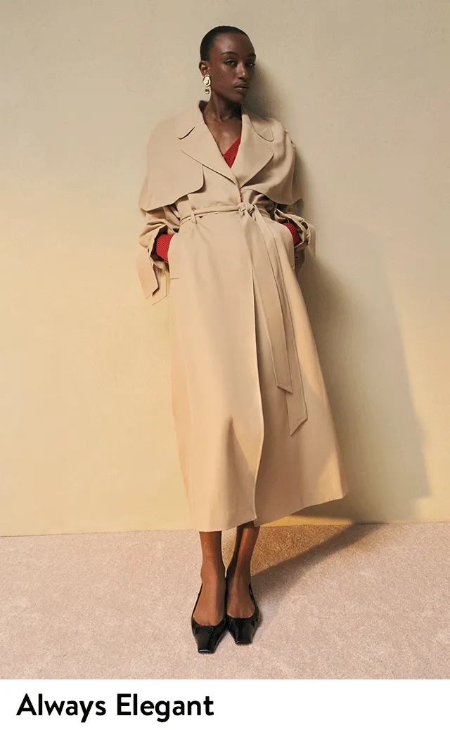 A woman wearing a trench coat over a red top