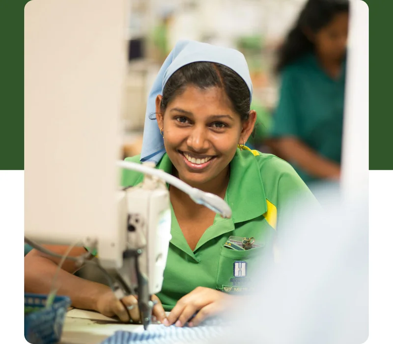 A person sewing a garment in a factory.