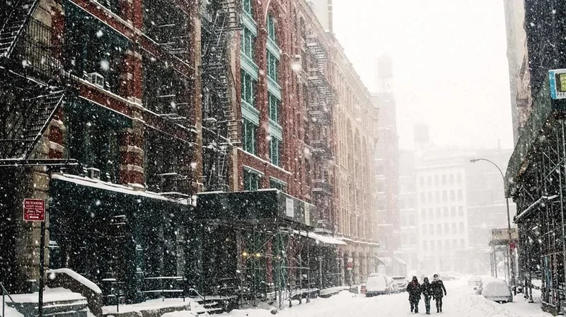 Image description: People walking during a snowfall in New York City.
