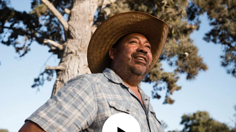 Photo of organic farmer Javier Zamora with a video play button.