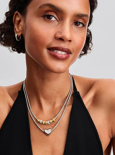 Model wearing silver and gold charms