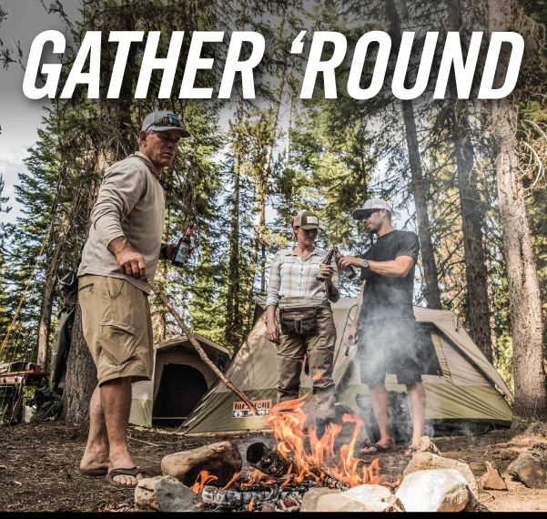 Gerber three people around campfire during the day with tents in the background Gerber three people around campfire during the day with tents in the background