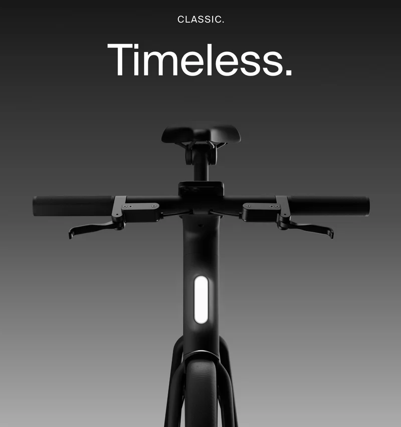 Alt text: Front view of the Cowboy Classic e-bike in black with illuminated front light, shown against a dark gradient background with the words “Classic. Timeless.” above.