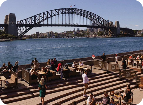 Image Description: A bridge over water with a crowd of people on a sidewalk.