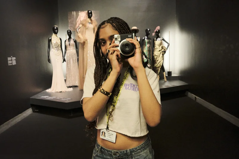 A teen holding a camera in a gallery