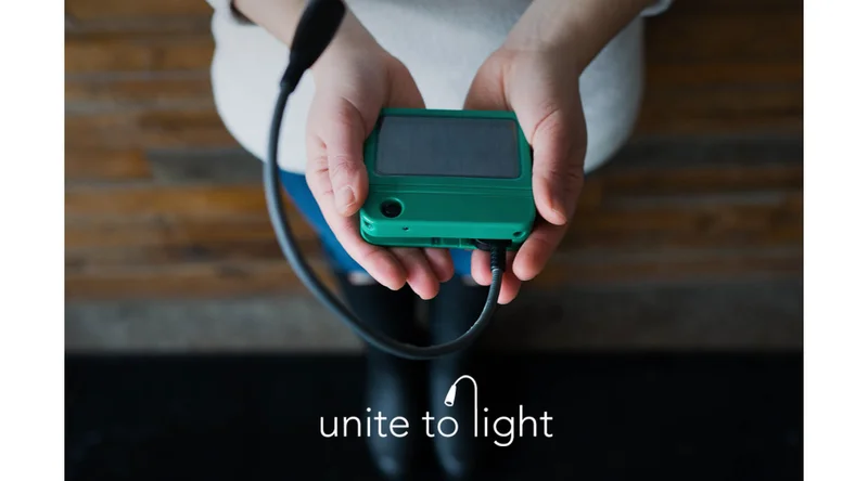 Unite to Light - person holding a portable solar light