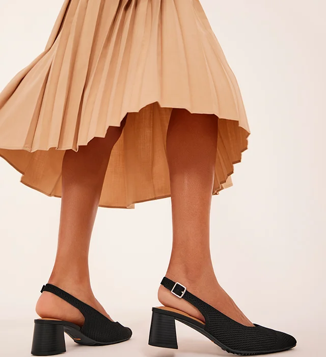 The black mesh Gipsy pump paired with a tan pleated midi skirt. Shop heels.
