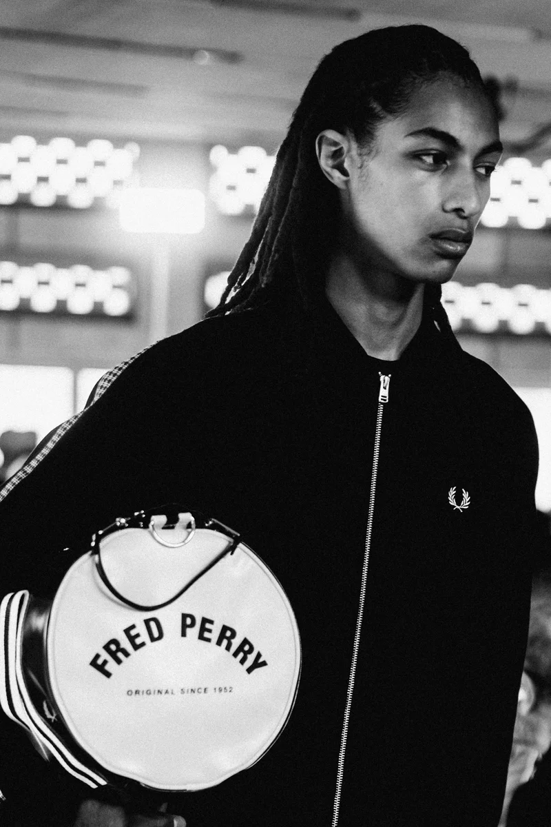 Model carrying a Fred Perry Barrel Bag and wearing a Fred Perry Track Jacket