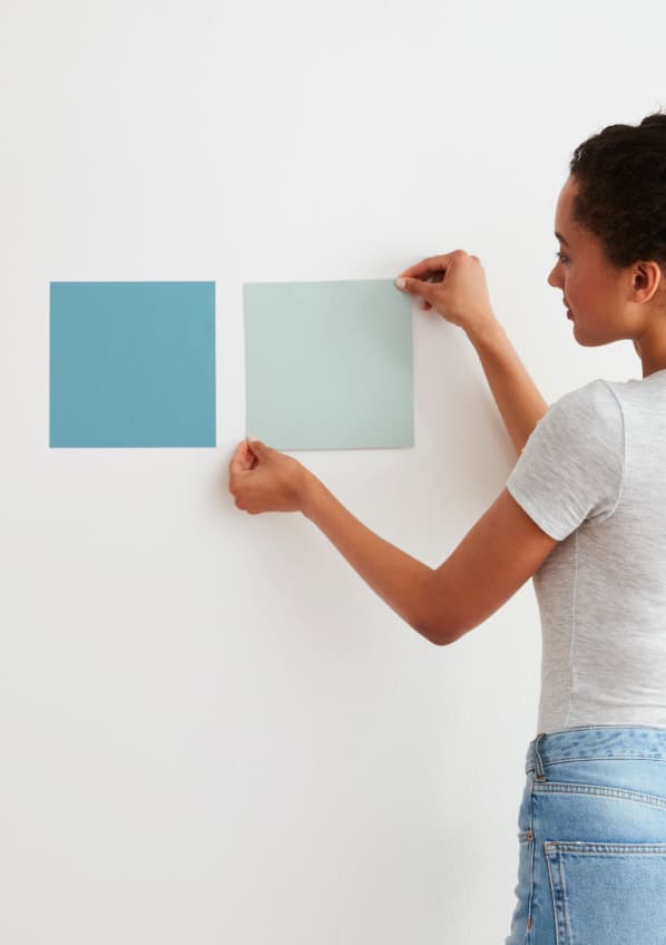 Woman applying Peel-and-Stick Swatch to wall