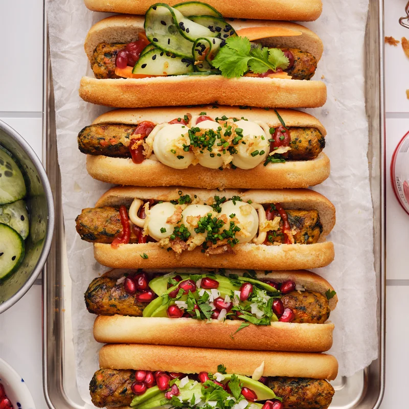 Veggie sausages in buns on a tray.