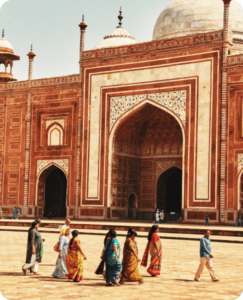 Image Description: A group of ladies in saris roaming the courtyard in front of the Taj Mahal in India