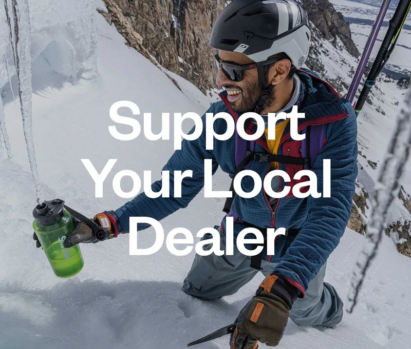 Patagonia 50. Support your local dealer. A skier holds their water bottle under a dripping icicle.