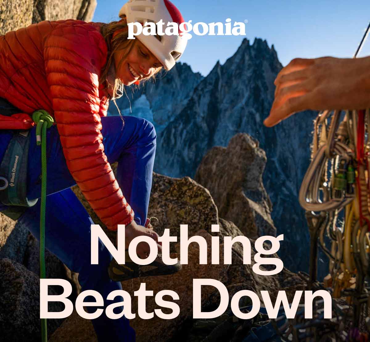 Nothing beats down. Two climbers on a belay ledge high in the mountains.