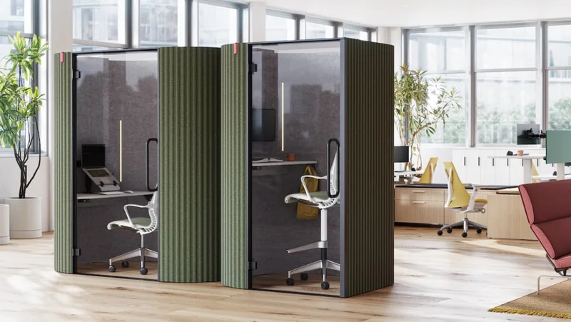 A side-by-side view of Bay Work Pod and Bay Work Pod Pro with workstations in the background and lounge setting off to the right.